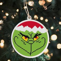 the grin face ornament is hanging from a christmas tree with lights in the background