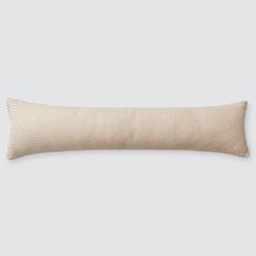 a beige pillow with a white background