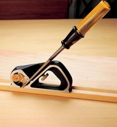 a planer that is sitting on top of a wooden table with a tool in it