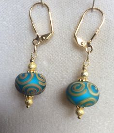 The beads are handmade and hand painted.  The bead color is a beautiful blue-green with a yellow gold painted design.  The findings are high quality yellow gold plated.   I can make just this one pair, one of a kind! Beautiful gift for teacher or mom. Gold Hand Painted Dangle Jewelry, Hand Painted Gold Dangle Jewelry, Turquoise Earrings With Large Beads For Gifts, Turquoise Large Beads Drop Earrings, Turquoise Drop Earrings With Large Beads, Artisan Blue Beaded Earrings, Hand Painted Turquoise Drop Earrings, Turquoise Earrings With Gold Beads, Gold Earrings With Large Beads For Gift