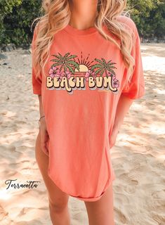 "Discover our Sun-Kissed Comfort Color Shirts, the ultimate summer wardrobe essential, designed to enhance your beach vibes and create unforgettable summer memories! Featuring a range of eye-catching designs inspired by sun-soaked beaches, tropical paradise, and endless summer adventures, our shirts will have you daydreaming about your next beach escape. Dive into a world of surf, sand, and salty sea breeze with our vibrant collection of t-shirts that embrace the aloha spirit and coastal living Tropical Graphic Print T-shirt For Beach, Summer Cotton T-shirt With Palm Tree Print, Beachy Summer T-shirt With Funny Print, Beachy Funny Print Summer T-shirt, Summer Pink Shirt With Screen Print, Spring Vacation T-shirt With Crew Neck, Summer Short Sleeve Printed Tops, Relaxed Fit Palm Tree Print Tops For Spring, Cotton T-shirt For Summer Vacation