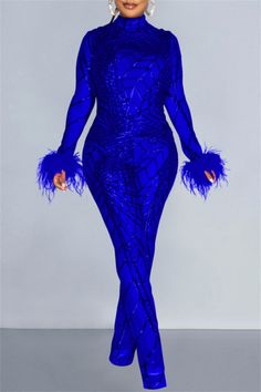 a woman wearing a blue dress with feathers on it