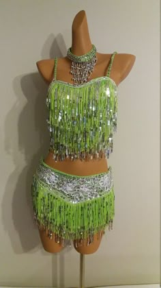 a mannequin wearing a green and silver belly dance costume with beads on it