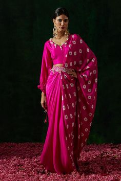 Hot pink silk pre-draped saree with shibori hand print and pearls, coin and thread embroidery. Comes with a blouse and a belt.
Components: 3
Pattern: Hand printed, Embroidered
Type Of Work: Shibori, Pearls, Coin, Thread
Neckline: V Neck
Sleeve Type: Puffed Sleeves
Fabric: Silk
Color: Pink
Other Details: 
Tassel detailing
Occasion: Sangeet - Aza Fashions Draped Saree, Shibori Print, Shibori Silk, Pink City, Drape Saree, Thread Embroidery, Fashion App, Fabric Silk, Printed Sarees