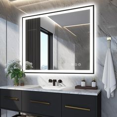 a bathroom vanity with a large mirror above it and a plant on the counter top