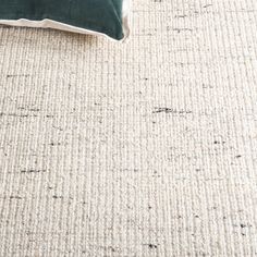 a green pillow sitting on top of a white rug