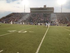 a football game is being played on an empty field with fans in the stands watching