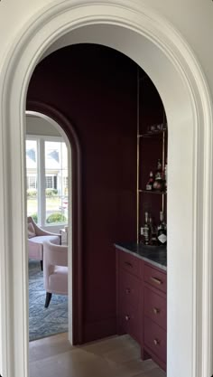 an archway leading into a living room with purple walls