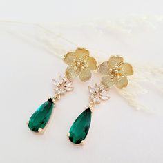 Gold Emerald Green Earrings for brides, weddings and bridal showers. The perfect gift earrings for bridesmaids, mother of the groom, or mother of the bride. Find earrings for bridal bachelorette party or other special occasions here. A gentle cascade of gold flowers and  shimmering Emerald Green crystals in these beautiful nature-inspired bridal earrings. Adding just a hint of sparkle, this pretty pair make gorgeous earrings for both brides and bridesmaids.  Emerald Green glass crystals add a fu Gold Flower Cluster Earrings For Wedding, Gold Flower-shaped Cluster Earrings For Wedding, Elegant Flower Teardrop Earrings For Gift, Elegant Flower Shaped Teardrop Earrings, Green Flower Shaped Jewelry For Wedding, Green Cluster Earrings For Wedding, Flower Shaped Bridal Earrings As A Gift, Bridal Flower-shaped Earrings As A Gift, Matching Flower Earrings For Bridesmaids Gift