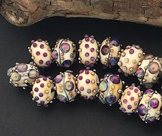 a group of beads sitting on top of a black table next to a piece of wood