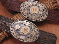 Belt buckles have a rich tradition in cowboy history! They can tell a story, show personality and definitely demonstrate style and this belt buckle does just that! This is the newest in our growing line of designer shotgun & bullet casing belt buckles. This buckle borrows the oval shape of our best selling buckle while incorporating the round center design of our round buckle. The result is another show stopper of a belt buckle! Features a bed of brass 9mm bullet casings embellished with a c Cowboy History, Mens Western Style, 12 Gauge Shotgun, 9mm Bullet, Cowboy Outfit, Fancy Accessories, Mens Western, Bullet Casing, Western Belt Buckles