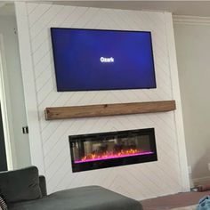 a flat screen tv mounted above a fireplace in a living room