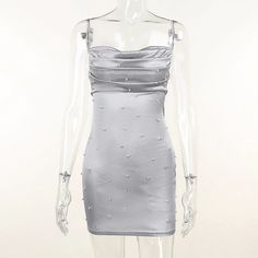 a mannequin wearing a silver dress with beading on the bust and shoulders