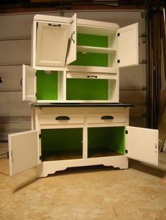 a white cabinet with green doors and drawers