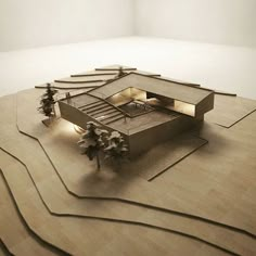 an architectural model of a house on top of a wooden floor with trees in the foreground