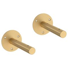 two brass - plated metal handles with round holes on each end, one for the door and one for the wall