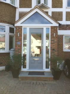 the front entrance to a building with two potted plants on either side of it