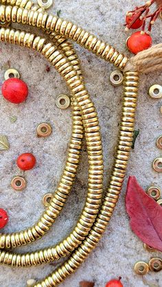 some gold colored metal beads and red leaves