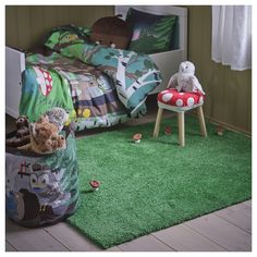 a child's bedroom with green carpet and teddy bears in the bag on the floor