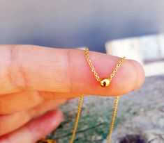 "A dainty minimal 14k gold necklace that has a tiny gold bead that slides on the chain. This simple yet timeless necklace will make a perfect gift for your best friend, your sister, mother or bridesmaids. All components and findings are two micron vermeil gold which means 925 sterling silver with two layers of 14K gold. A Vermeil piece of jewelry is made entirely of precious metals (NO BRASS), which gives the piece an intrinsic value. Materials: - 14K gold shiny, delicate chain - 14K gold ball - Dainty Ball Chain Necklace For Gift, Minimalist Gold Plated Ball Chain Jewelry, Dainty Yellow Gold Ball Chain Jewelry, Delicate 14k Gold-filled Necklace With Tiny Beads, Minimalist Yellow Gold Ball Chain Necklace, Minimal Gold Jewelry, Everyday Wear Jewelry, Ball Necklace, 14k Gold Necklace