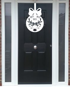 a black front door with a white christmas ornament