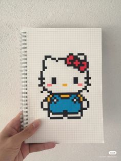 a hand holding a notebook with an image of a hello kitty on it