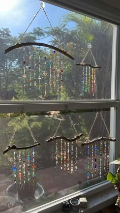 a window with several wind chimes hanging from it