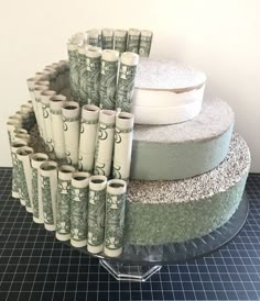 stacks of rolled up money sitting on top of a cake