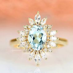 a ring with an aqua and white topazte center surrounded by small diamond accents