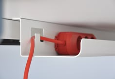 a red and white electrical outlet attached to the side of a wall with an extension cord