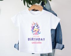 Celebrate your little one's special day with our adorable Unicorn birthday T-shirt for kids! This cheerful shirt is perfect for boys and girls and is guaranteed to bring a smile to any face. Every Age available from 1-9. Highlights: - Unique design: each t-shirt is adorned with lovely motifs that inspire the imagination and emphasize the joy of celebrating. - High-quality materials: Our T-shirt is made of 100% soft cotton, which is not only comfortable against the skin, but also breathable and h Cute Unicorn Print Birthday T-shirt, Birthday Unicorn Print Crew Neck T-shirt, Birthday White T-shirt With Unicorn Print, White Unicorn Print T-shirt For Birthday, White T-shirt With Unicorn Print For Birthday, Cute Birthday T-shirt With Cartoon Print, Custom Kids, Unicorn Gifts, 7th Birthday