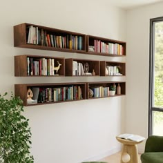 the bookshelves are lined up against the wall in this living room with a green chair