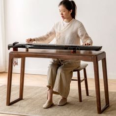 a woman sitting at a table with a keyboard on it