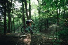 a person riding a bike on a trail in the woods