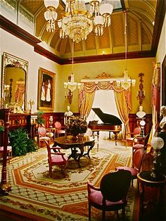 an ornate living room with chandelier and piano