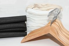 a stack of black and white cloths next to a wooden hanger