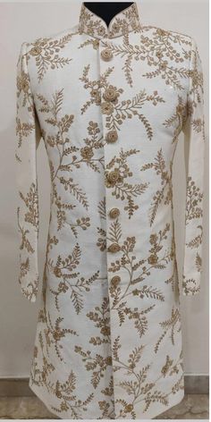 a white jacket with gold embroidered flowers on it