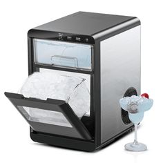 a small ice maker with a drink in it's glass next to the machine