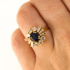 Here is a 18K Yellow Gold ring with a centre Sapphire and in the Gallery there are 6 Round Diamonds and 6 Tapered Baguette Diamonds. Condition: Used (Very Good) Weight: 3.8 grams UK Ring Size: J Please contact for quick resizing! Tested as: 18K Yellow Gold Box: New Gift Box Comments: These Diamonds/Gemstones have not been certified by a laboratory, they have been graded by our own qualified gemologists as fairly and as accurately as possible. Postage: This Ring will be posted via Royal Mail Special Delivery, and should be with you within 3 days of your order. Free postage to the UK! We are a trusted company in Hatton Gardens London, with a wide range stock of high-end watches and fine jewellery. Have a look at our other listings or message us any interest in any item you may be looking for Yellow Gold Sapphire Cluster Ring With Center Stone, Yellow Gold Cluster Sapphire Ring With Center Stone, Gold Oval Sapphire Cluster Ring, Gold Sapphire Oval Cluster Ring, Oval Sapphire Cluster Ring In Gold, Elegant Yellow Gold Cluster Sapphire Ring, Elegant Yellow Gold Sapphire Cluster Ring, Gold Cluster Sapphire Ring Fine Jewelry, Wedding Sapphire Ring With 17 Jewels In 14k Gold