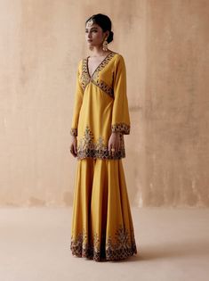 Editor's Note Presenting a luxurious mustard kurta sharara adorned with intricate floral thread embroidery, elegantly highlighted with velvet patchwork and various embellishments. This opulent ensemble is paired with an embroidered dupatta, creating a regal and elegant look perfect for special occasions or festive gatherings. The combination of the rich mustard color, the velvet details, and the ornate embroidery on both the kurta sharara and dupatta adds a touch of grandeur, making this outfit Diwali Sharara With Floral Embroidery And Straight Kurta, Diwali Floral Embroidery Sharara With Straight Kurta, Gold Embroidered Palazzo Set For Diwali, Anarkali Salwar Kameez In Gold With Floral Embroidery, Mustard Sets With Resham Embroidery For Diwali, Gold Anarkali Salwar Kameez With Floral Embroidery, Yellow Embroidered Floor-length Sharara, Floor-length Floral Embroidered Sharara For Festive Occasions, Yellow Long Sleeve Sharara For Eid