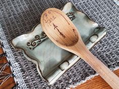 a wooden spoon sitting on top of a gray and white plate next to a rug