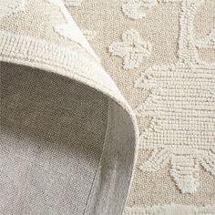 an area rug with white and beige designs on the carpet, close up view from above