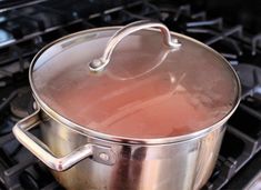 a pot on top of an open stove with a lid and handle in the middle