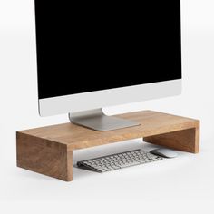 a computer monitor sitting on top of a wooden stand next to a keyboard and mouse