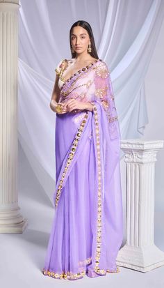 Introducing our lilac saree, crafted from a blend of tulle and organza fabrics. It features a dainty embroidered organza pallu adorned with intricate floral motifs made of sequins, metallic leaves, and cut dana. The pre-stitched tulle bottom features a refined gold border and acrylic motifs running along the hem. Paired with an ivory georgette blouse, embellished with metal circles, pearl embroidery, and delicate cutwork detailing throughout.From Papa Don’t Preach’s Bring Your Own Fairytale coll Elegant Purple Tissue Silk Pre-draped Saree, Purple Tissue Silk Pre-draped Saree With Sheer Dupatta, Bollywood Style Purple Pre-draped Saree For Wedding, Purple Pre-draped Saree With Cutdana For Reception, Purple Organza Pre-draped Saree For Diwali, Purple Pre-draped Saree With Dori Work, Purple Organza Pre-draped Saree With Dupatta, Elegant Purple Chanderi Pre-draped Saree, Purple Pre-draped Saree For Wedding