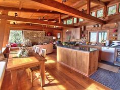 a kitchen and living room with wood flooring in a home on the edge of a lake