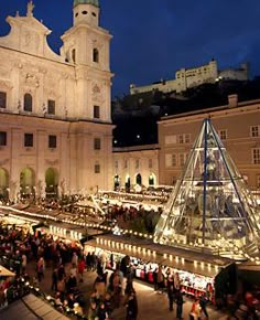 an outdoor christmas market in front of a large white building with a steeple on top