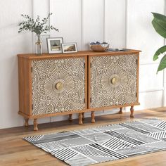 a wooden cabinet with two doors and an intricate design on the front, sitting in a room