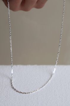 Crafted from delicate sterling silver, this Miniature Paperclip Chain is perfect for layering with your favorite necklaces. With its understated design, this chain adds a subtle touch of elegance to any outfit. Its versatility and lightweight feel make it a must-have piece for any jewelry collection. Stirling silver Made in the USA Dainty Sterling Silver Chain Necklace For Everyday, Delicate Sterling Silver Chain Necklace For Everyday, Simple Silver Delicate Chain Necklace, Sterling Silver Necklaces With Delicate Chain Link, Delicate Sterling Silver Chain Necklace For Layering, Minimalist Everyday Cable Chain Necklace, Minimalist Silver Oval Link Necklace, Minimalist Silver Necklace With Oval Link, Dainty Sterling Silver Chain Necklace