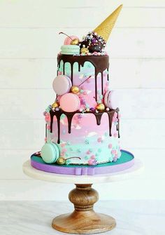 a three tiered cake with ice cream and candy toppings on the top layer